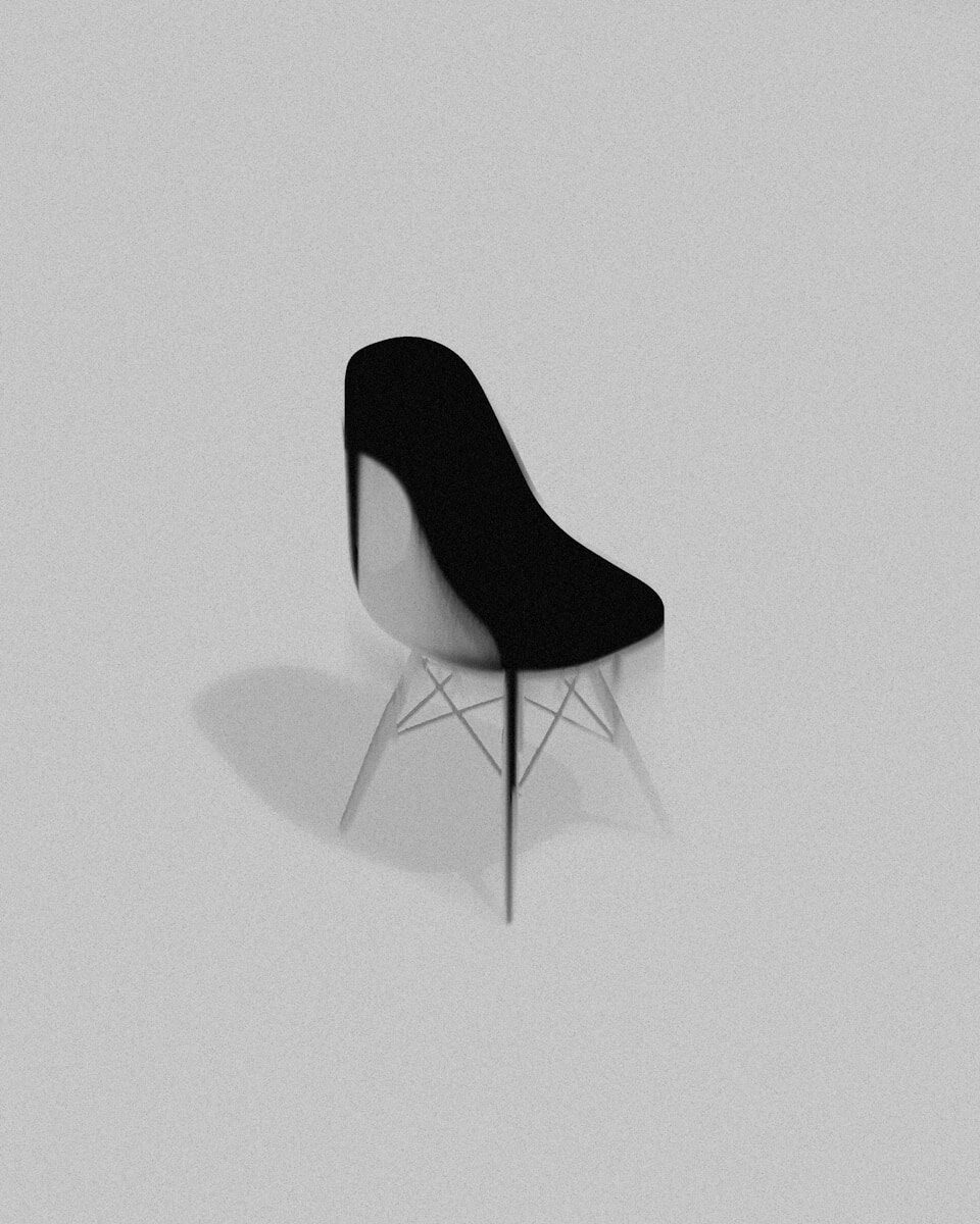 Modern black and white chair casting shadow on gray background.